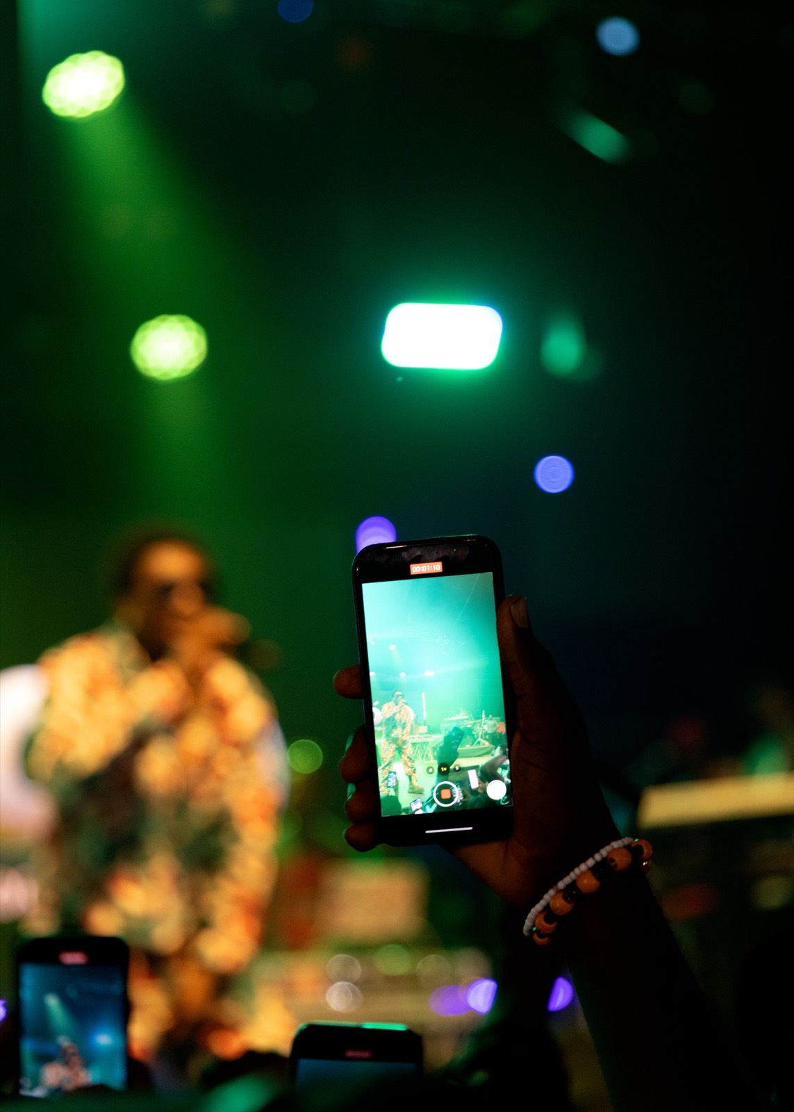 Fan filming a performance on a phone